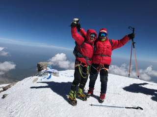 Bergsteigerin und Bergsteiger auf dem Gipfel des Elbrus